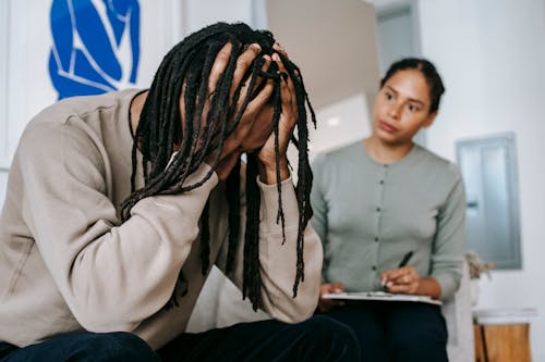 Unrecognizable desperate black man with attentive girlfriend at home