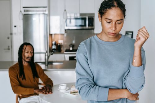 Free Crop upset African American female with pensive male partner at table during conflict in house Stock Photo