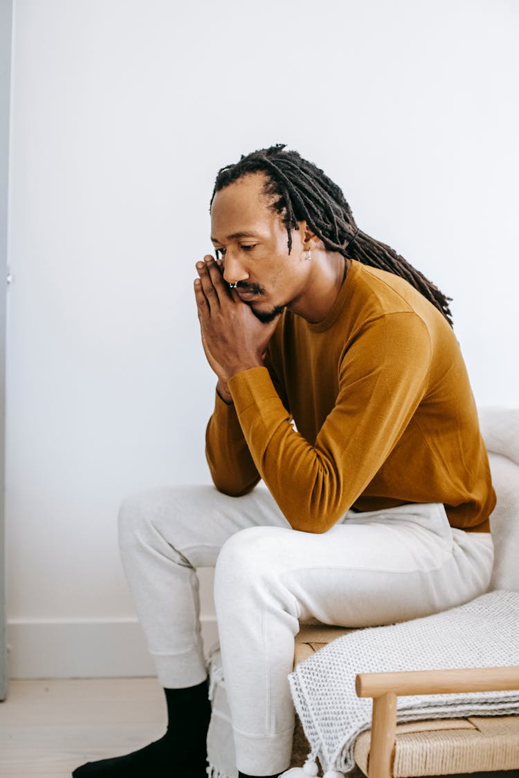 Frustrated Black Man Sitting On Couch