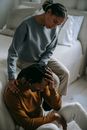 Black wife supporting depressed unhappy husband in bedroom