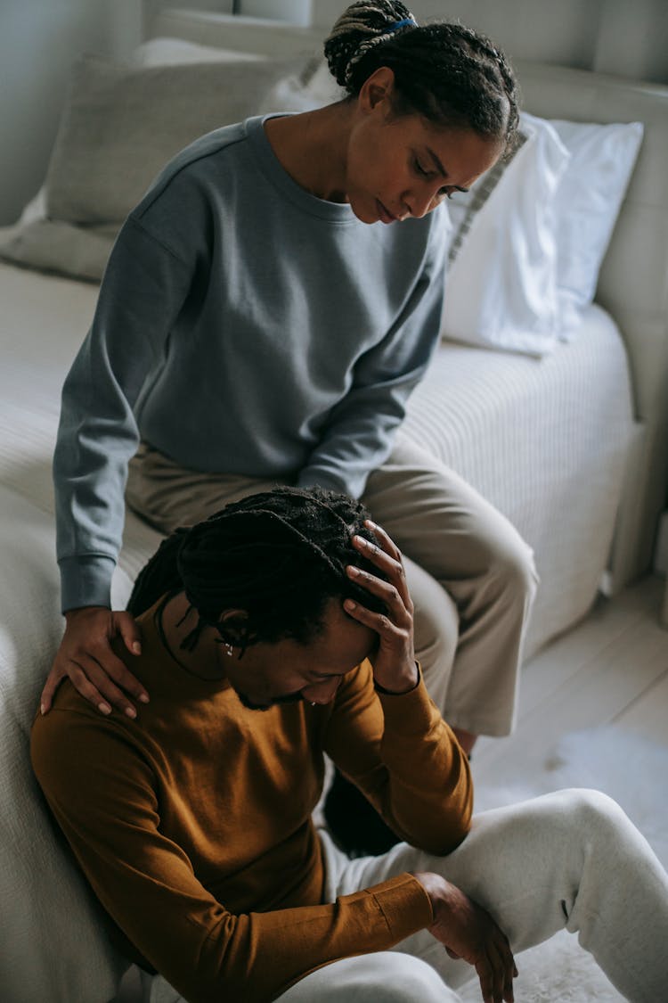 Black Wife Supporting Depressed Unhappy Husband In Bedroom