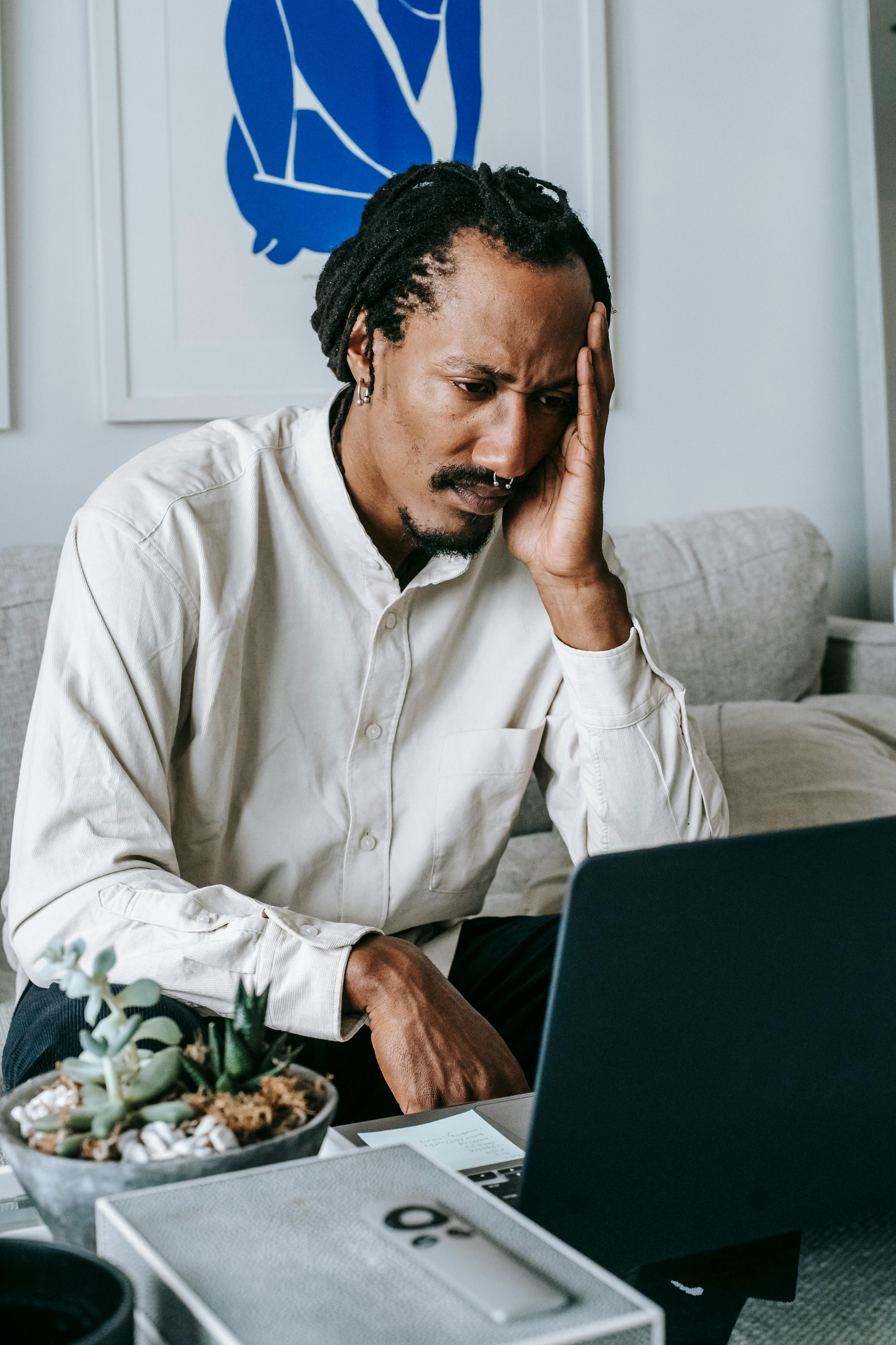 upset frowning man using laptop at home
