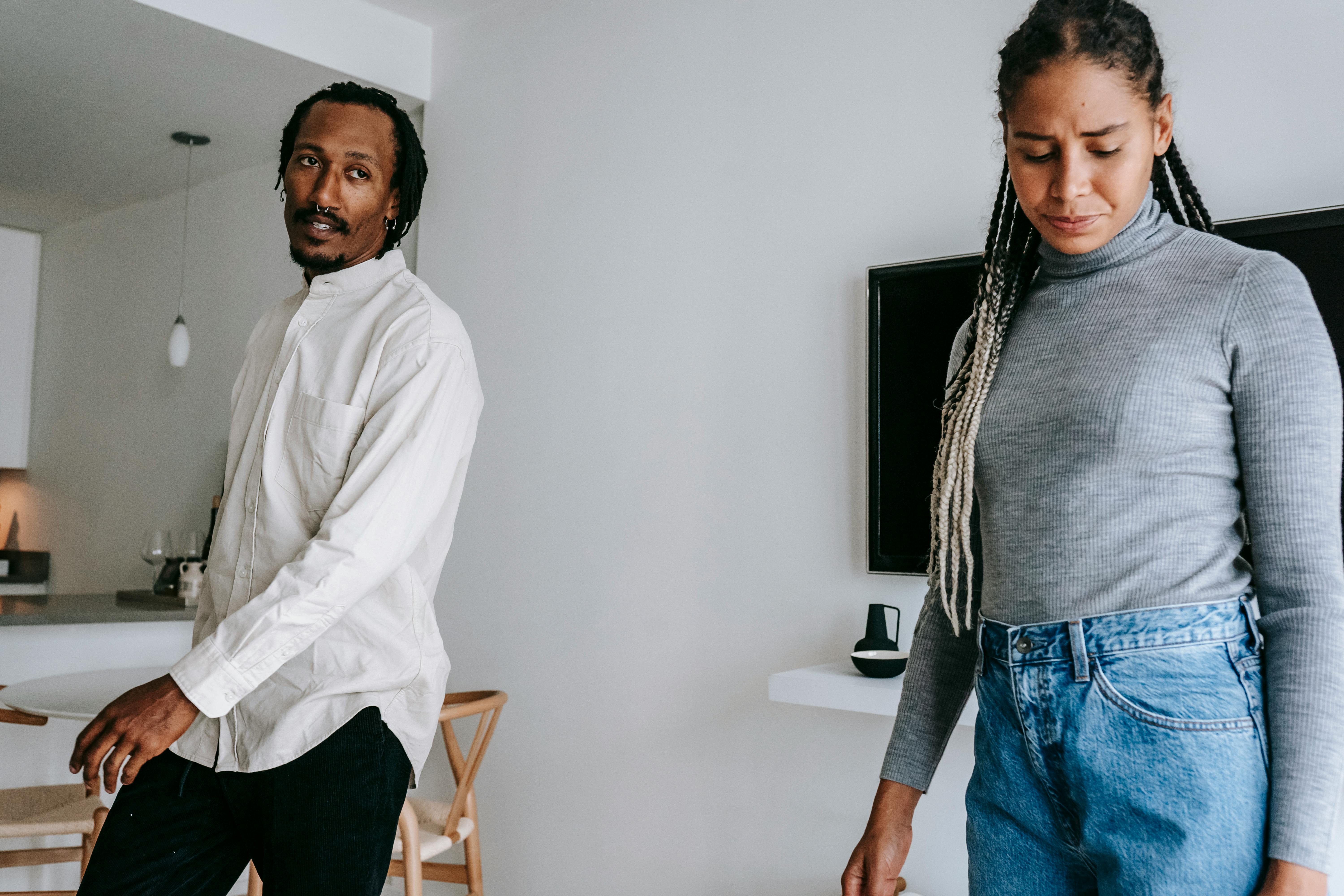 arguing black couple standing in living room