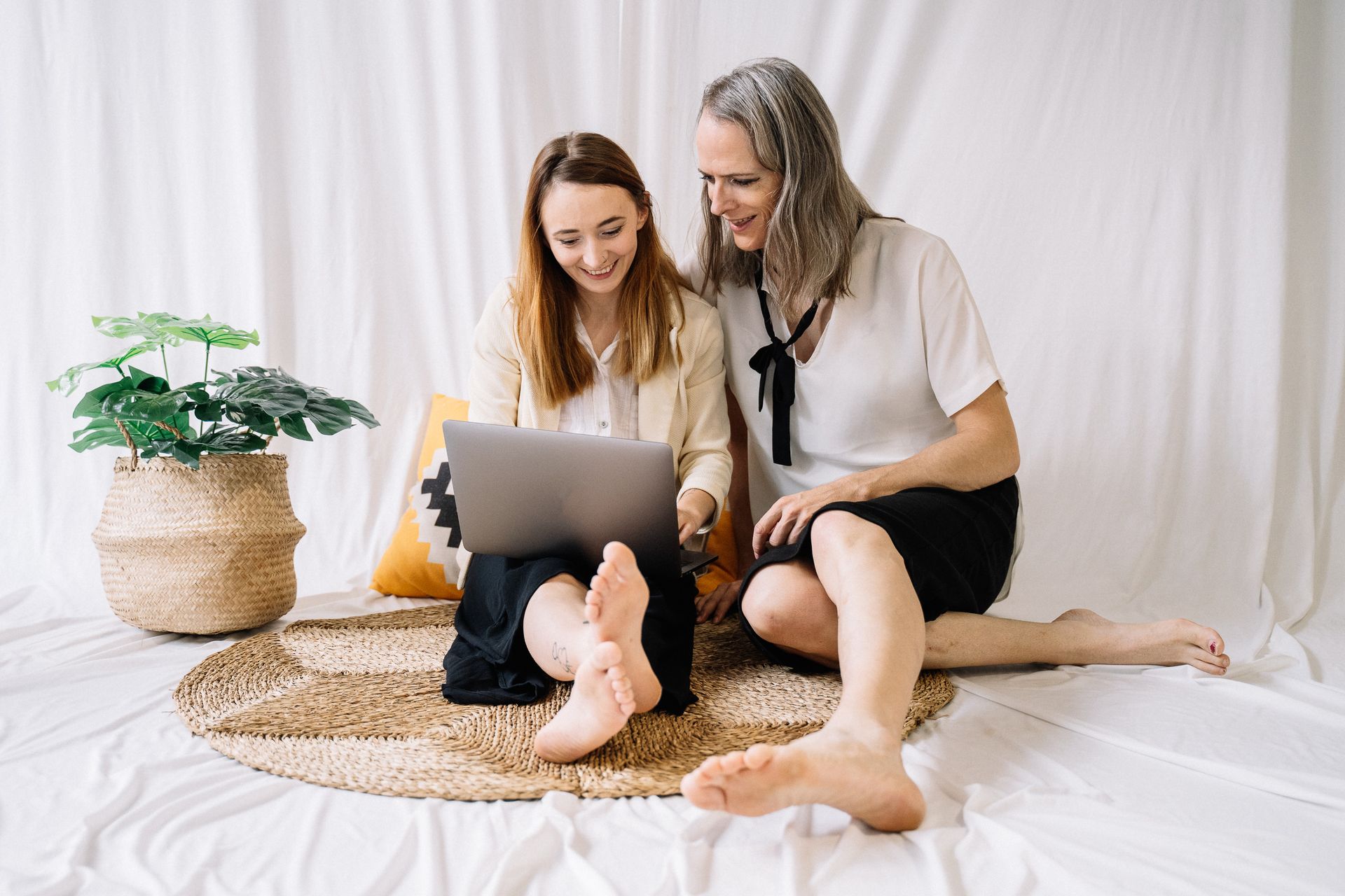 LGBTQ couple happily working together on a laptop at home, embracing remote work lifestyle.