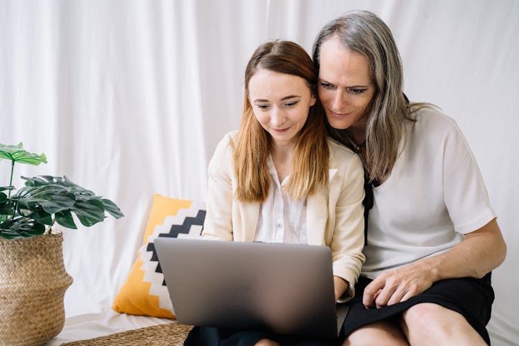 An Image Of A Couple Staring At A Laptop