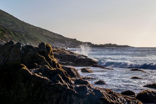 Free A stunning view of the rocky shoreline with waves crashing in WC South Africa, capturing coastal beauty. Stock Photo