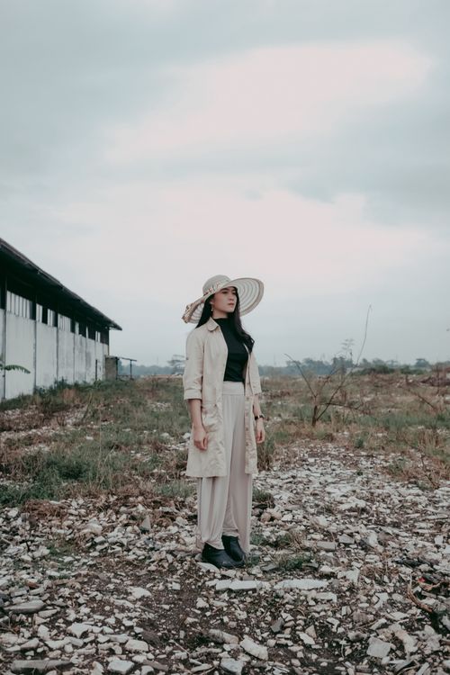 Free A woman in a wide-brimmed hat stands in a rural area in Bandung, Indonesia. Stock Photo