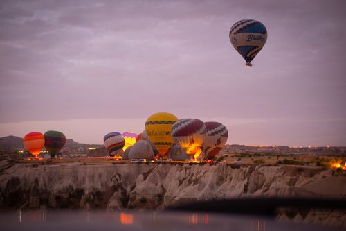 Free Colorful hot air balloons soar over Cappadocia, Turkey at sunrise, creating a stunning aerial view. Stock Photo