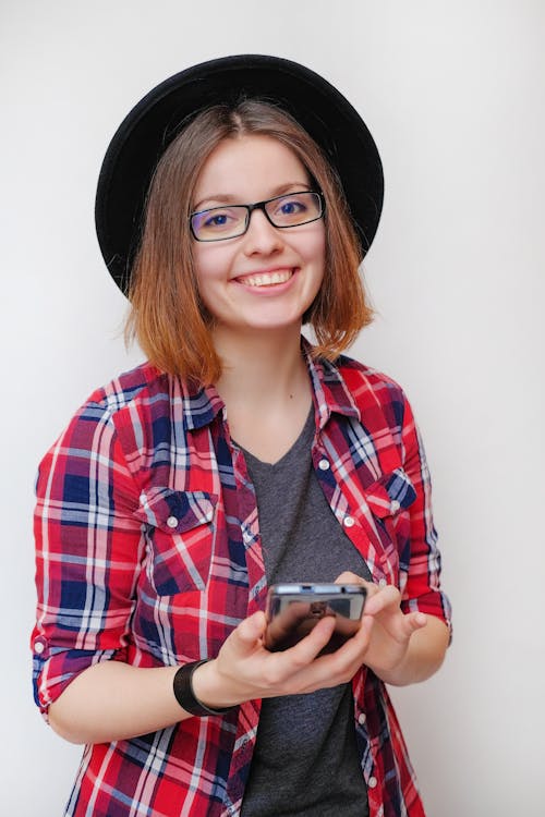 Smiling woman with smartphone looking at camera