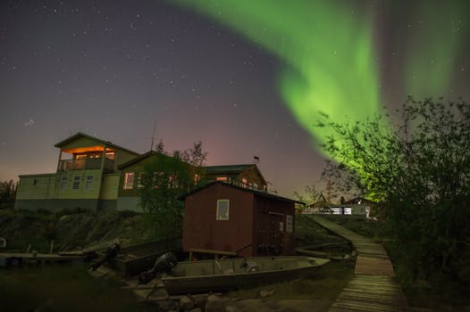 A stunning view of the aurora borealis illuminating the night sky over a house in Yellowknife, Canada.