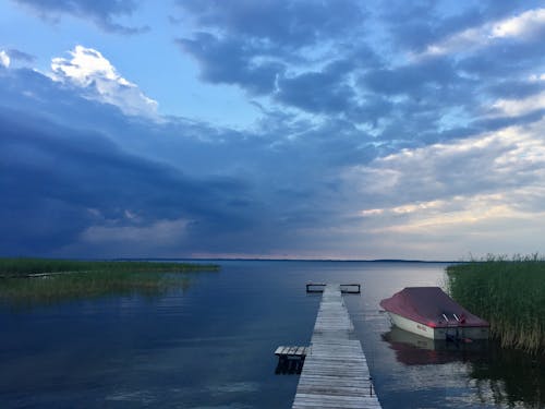 Brown Wooden Boardwalk Beside Motorboat