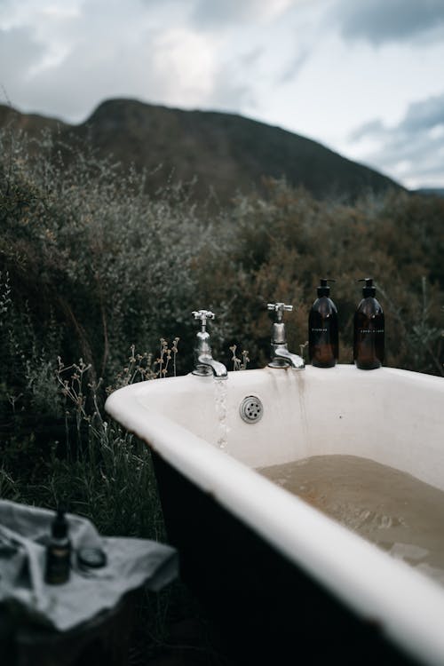 An Image of Open Faucets of a Bathtub