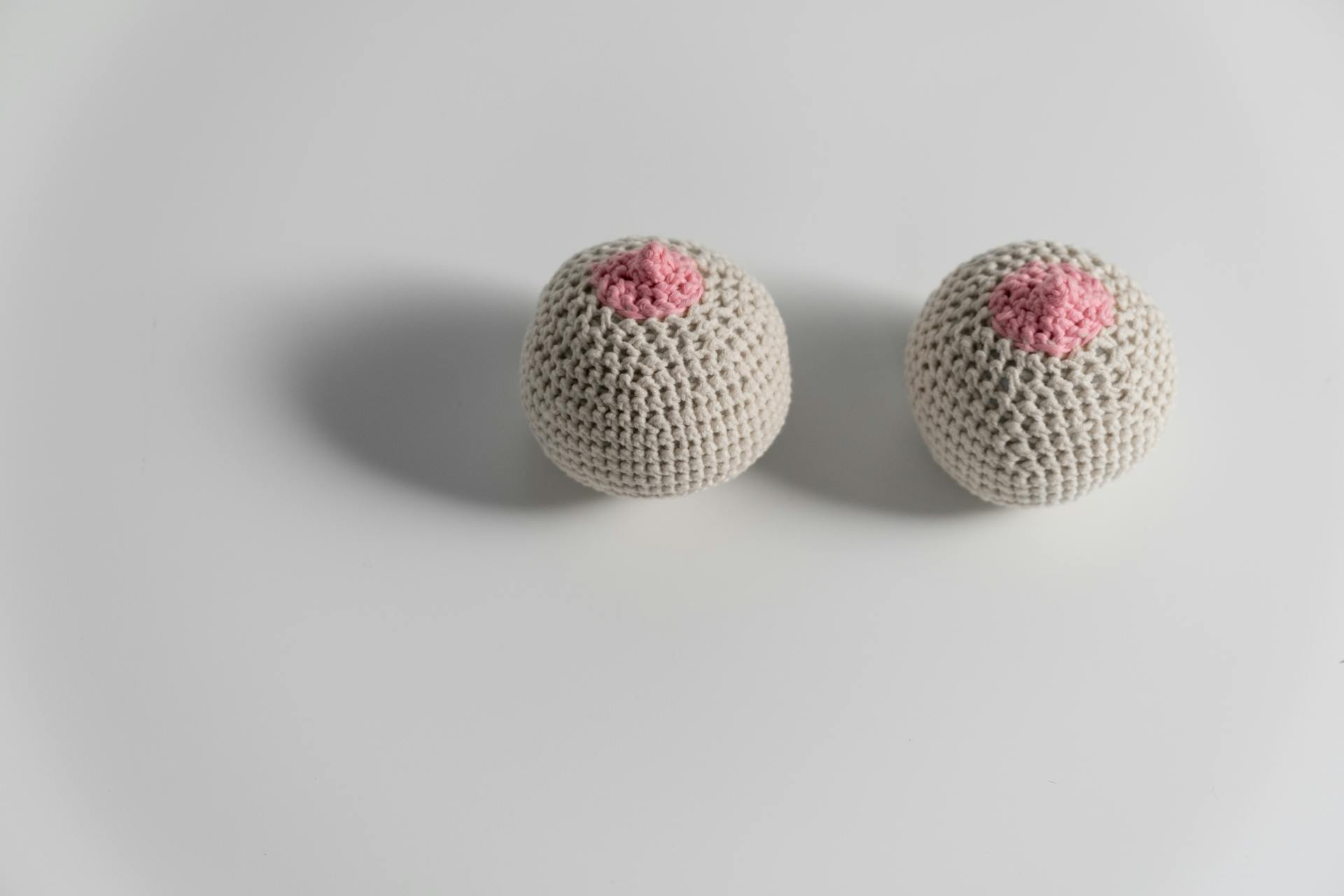 Beige and Pink Knitted Breast on White Surface