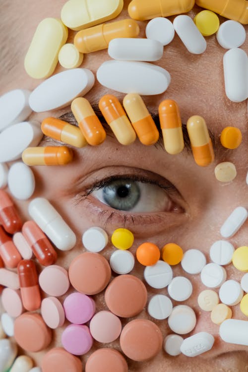 Close-up Photo of Assorted Medicines Surrounding a Person's Eye
