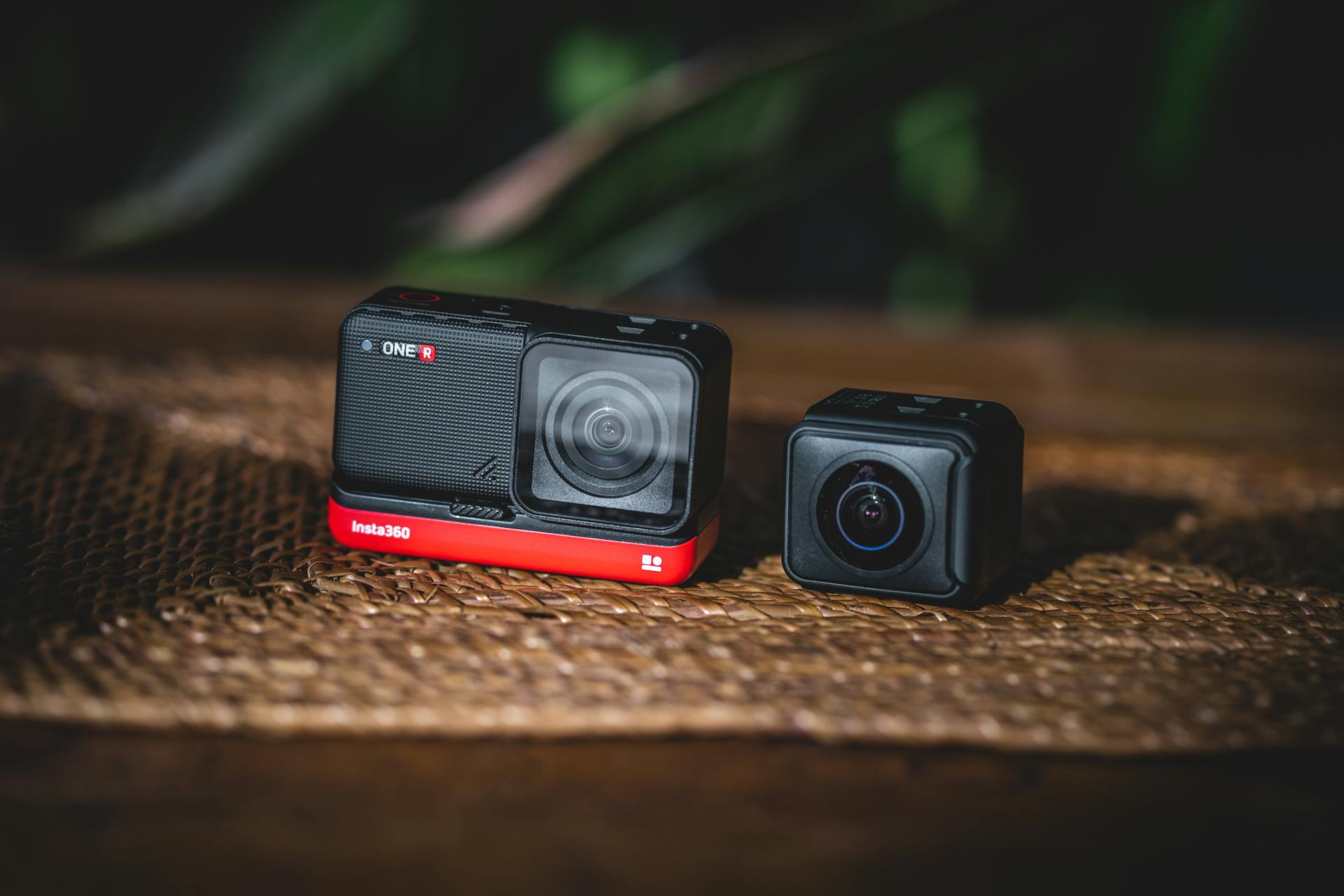 Two modular action cameras resting on a wooden table, ideal for tech enthusiasts and content creators.