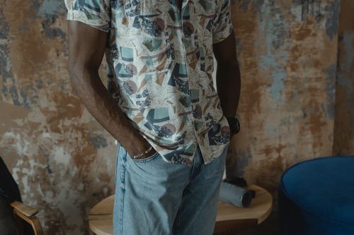 Free Close-up of a man in a patterned shirt and jeans, hands in pockets, showcasing fashion style. Stock Photo