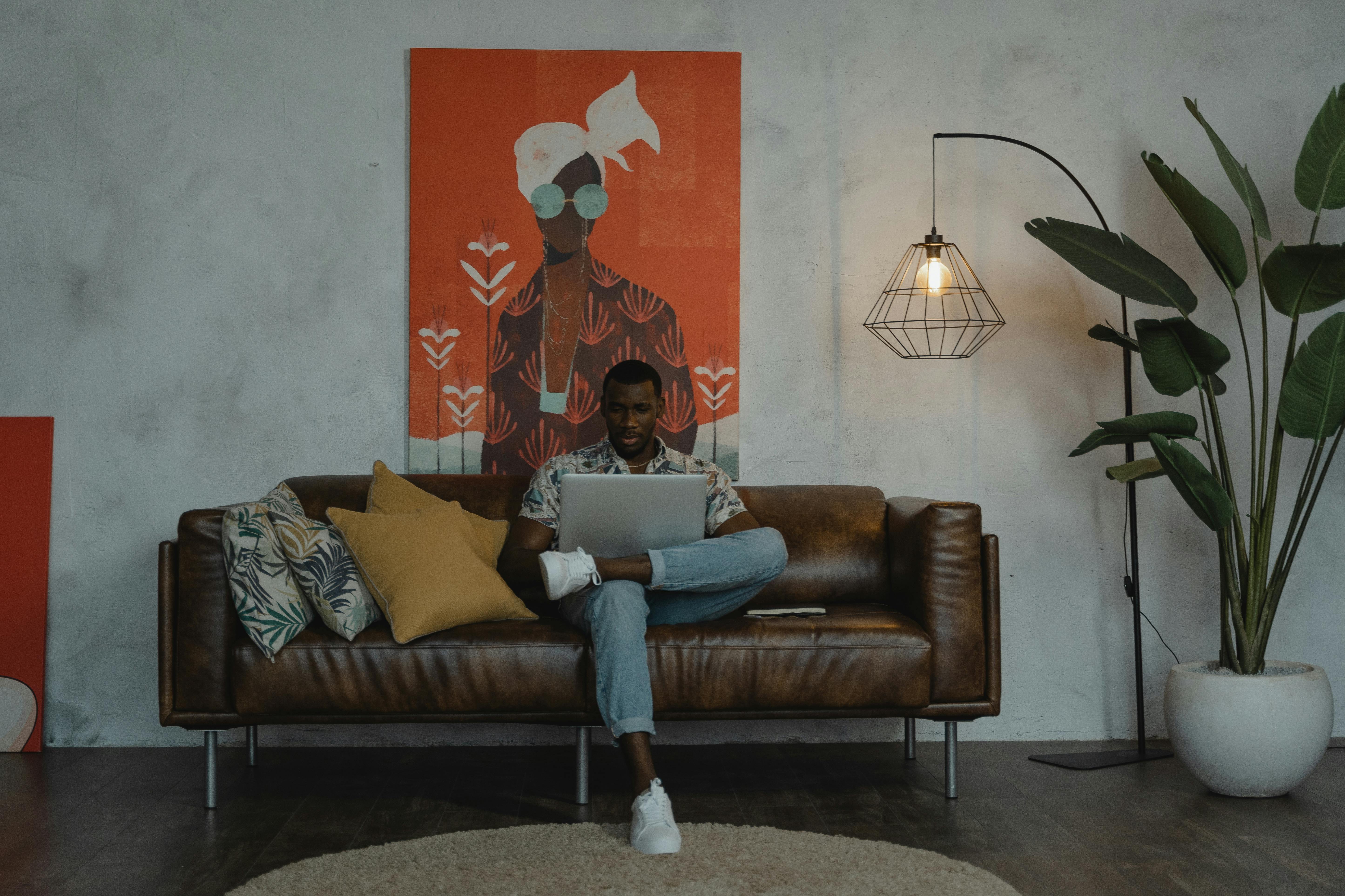 woman in blue denim jeans sitting on brown couch