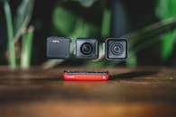 Black and Red Speaker on Brown Wooden Table
