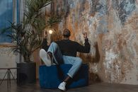 Man in Gray Sweater and Blue Denim Jeans Sitting on Blue Chair