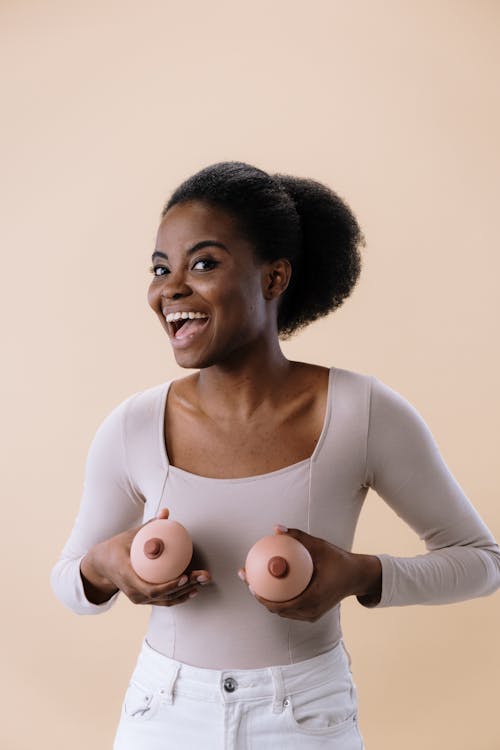 Free Woman in White Long Sleeve Shirt Holding Breast Like Toys Stock Photo