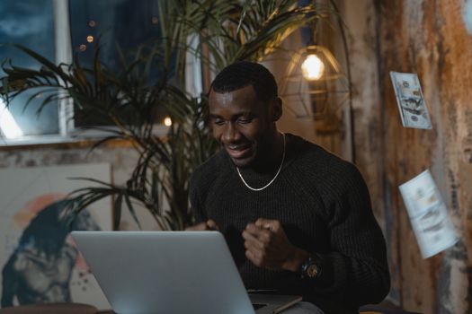 Excited man at home office celebrating success during an online meeting.