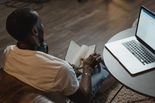 Free A man working from home with a laptop and planner, embodying the remote work lifestyle. Stock Photo