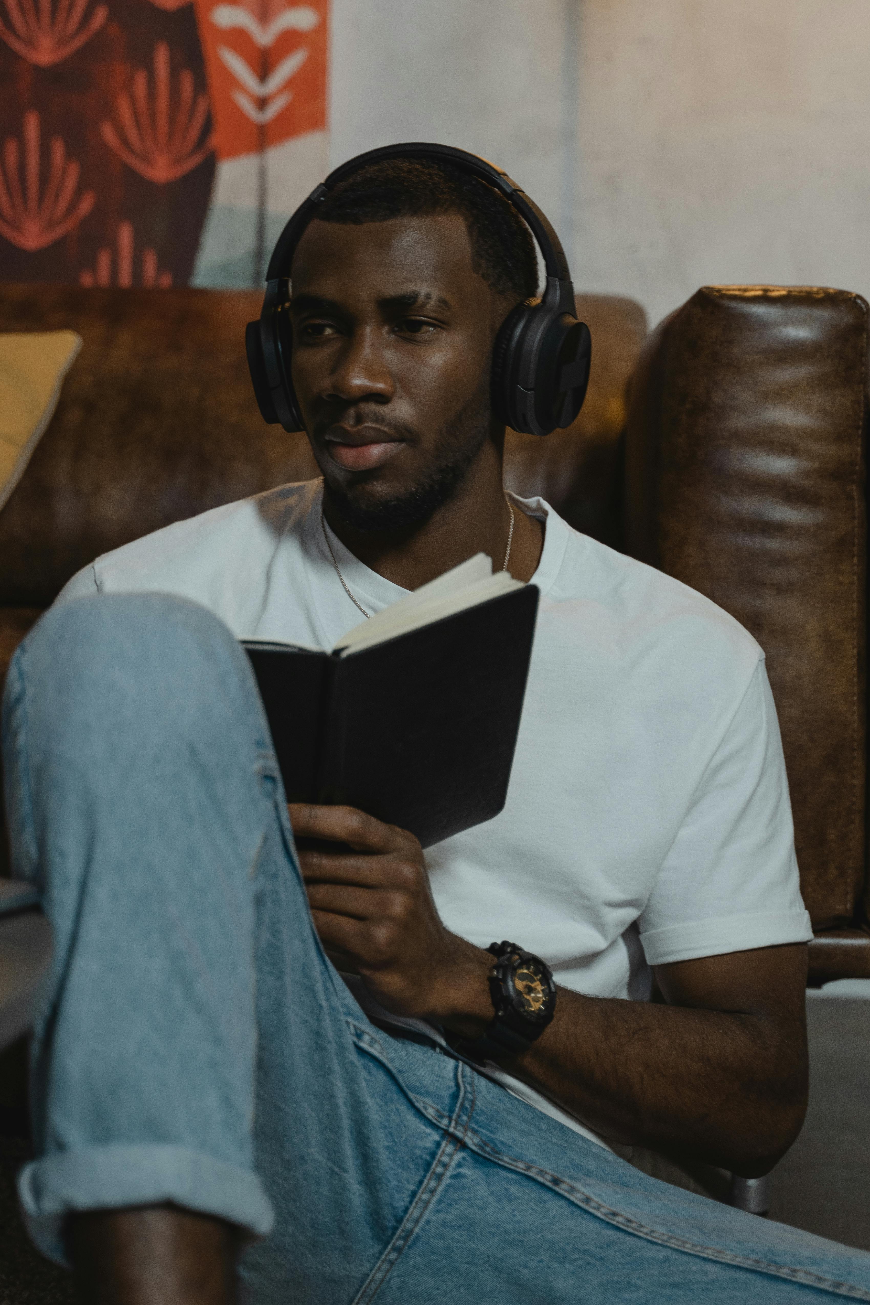 man in white crew neck t shirt and blue denim jeans wearing black headphones