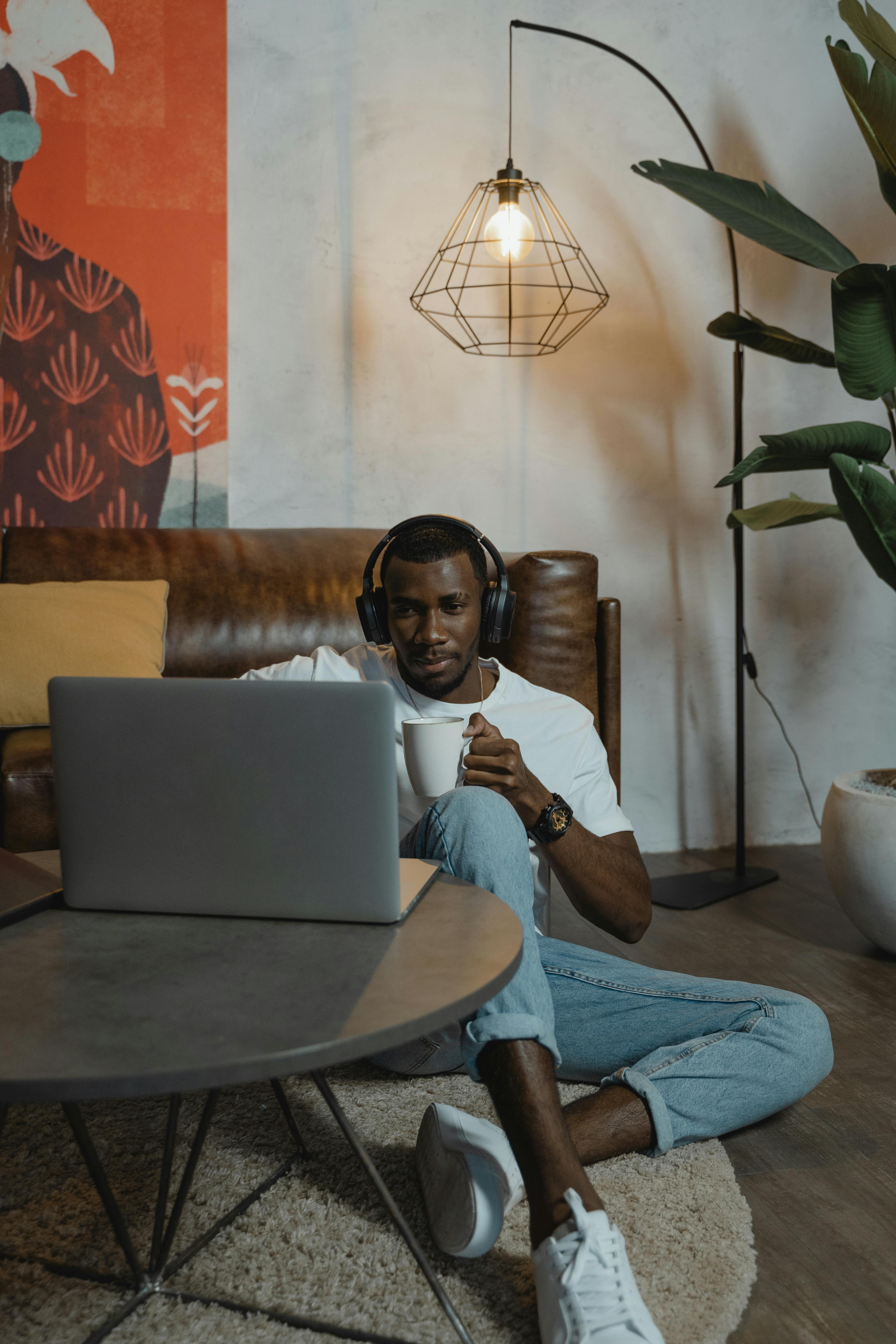 man using his laptop while having coffee