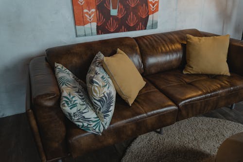 A Brown Leather Couch with Throw Pillows