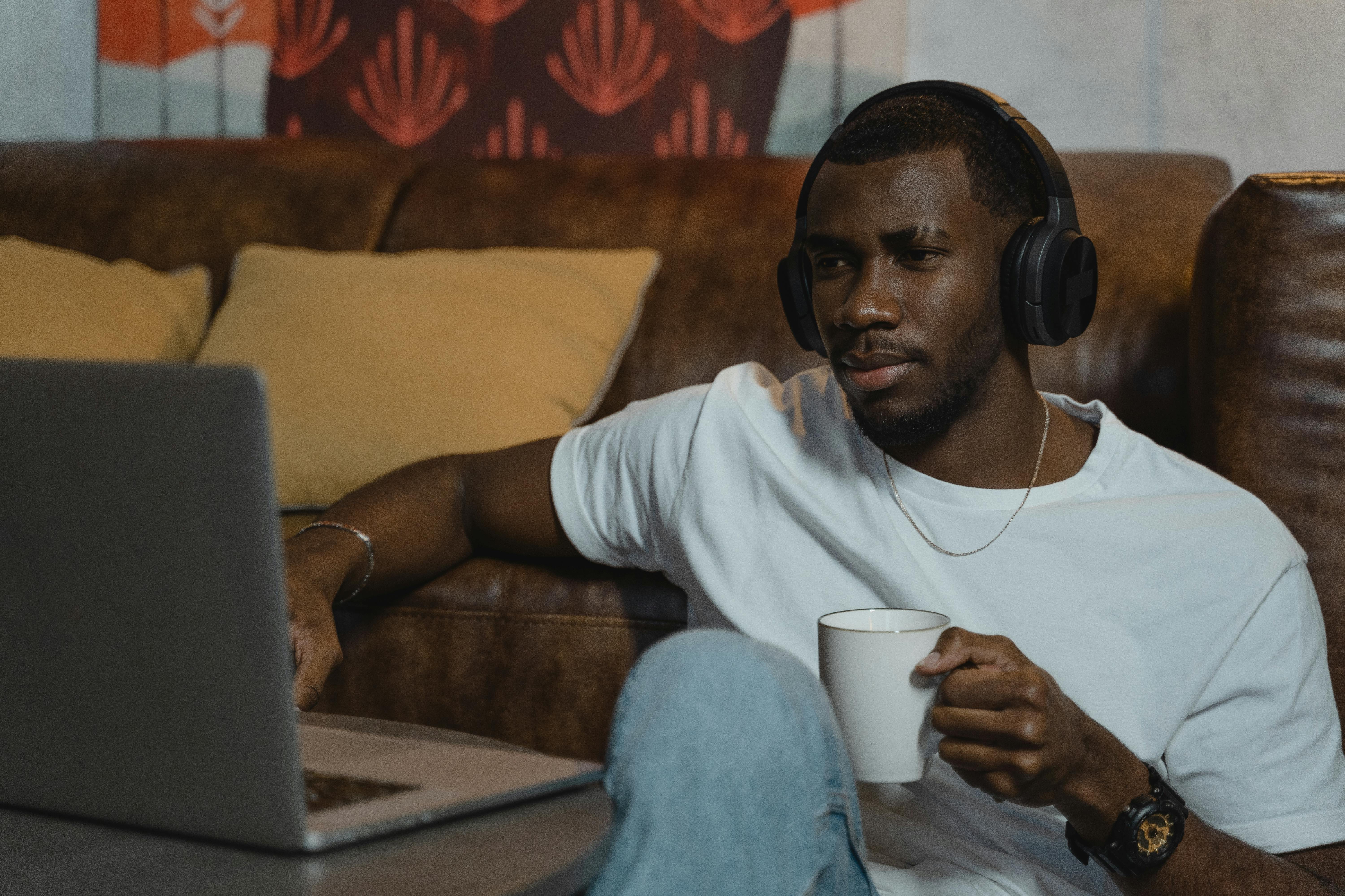 man using his laptop while having coffee