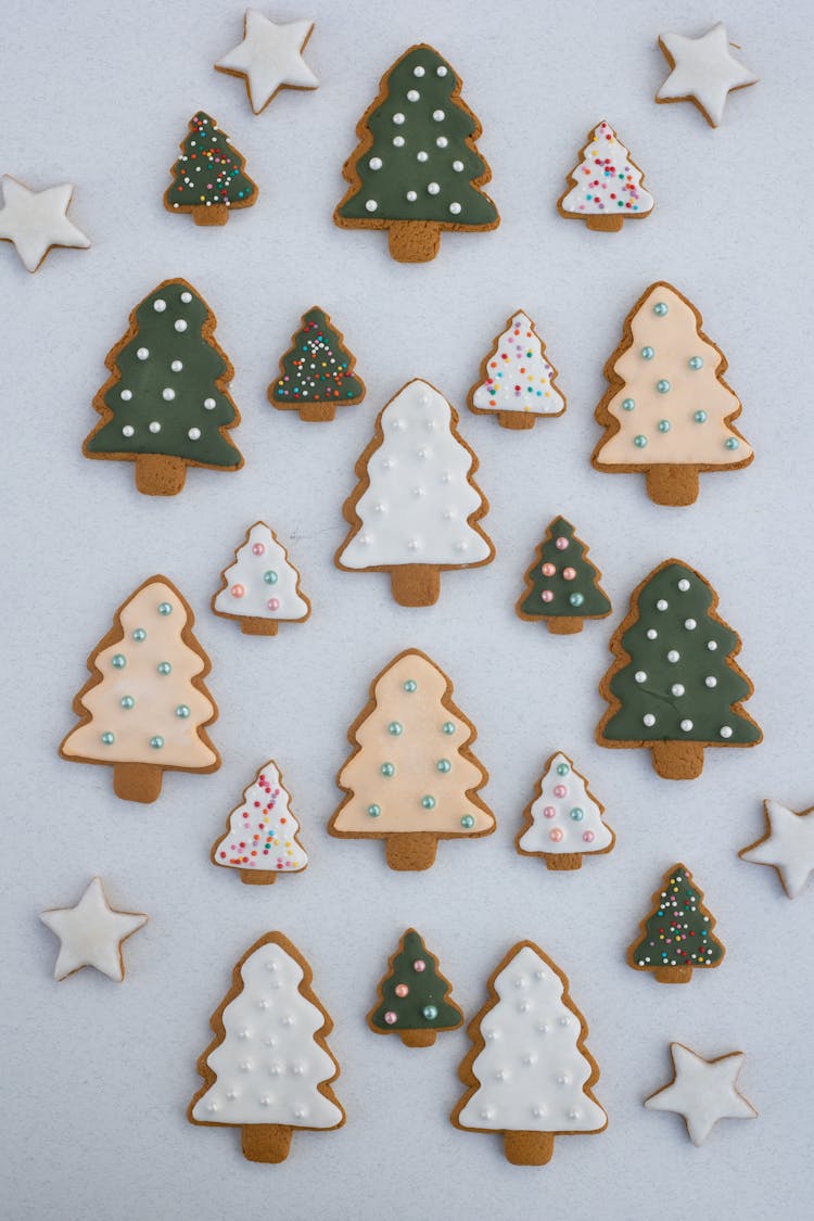 Different Sizes Of Christmas Tree-Shaped And Star-Shaped Gingerbread Cookies On White Background