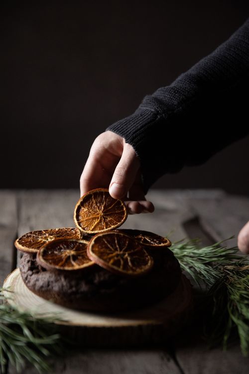 Free A rustic chocolate cake adorned with dried orange slices, perfect for holiday celebrations and festive gatherings. Stock Photo