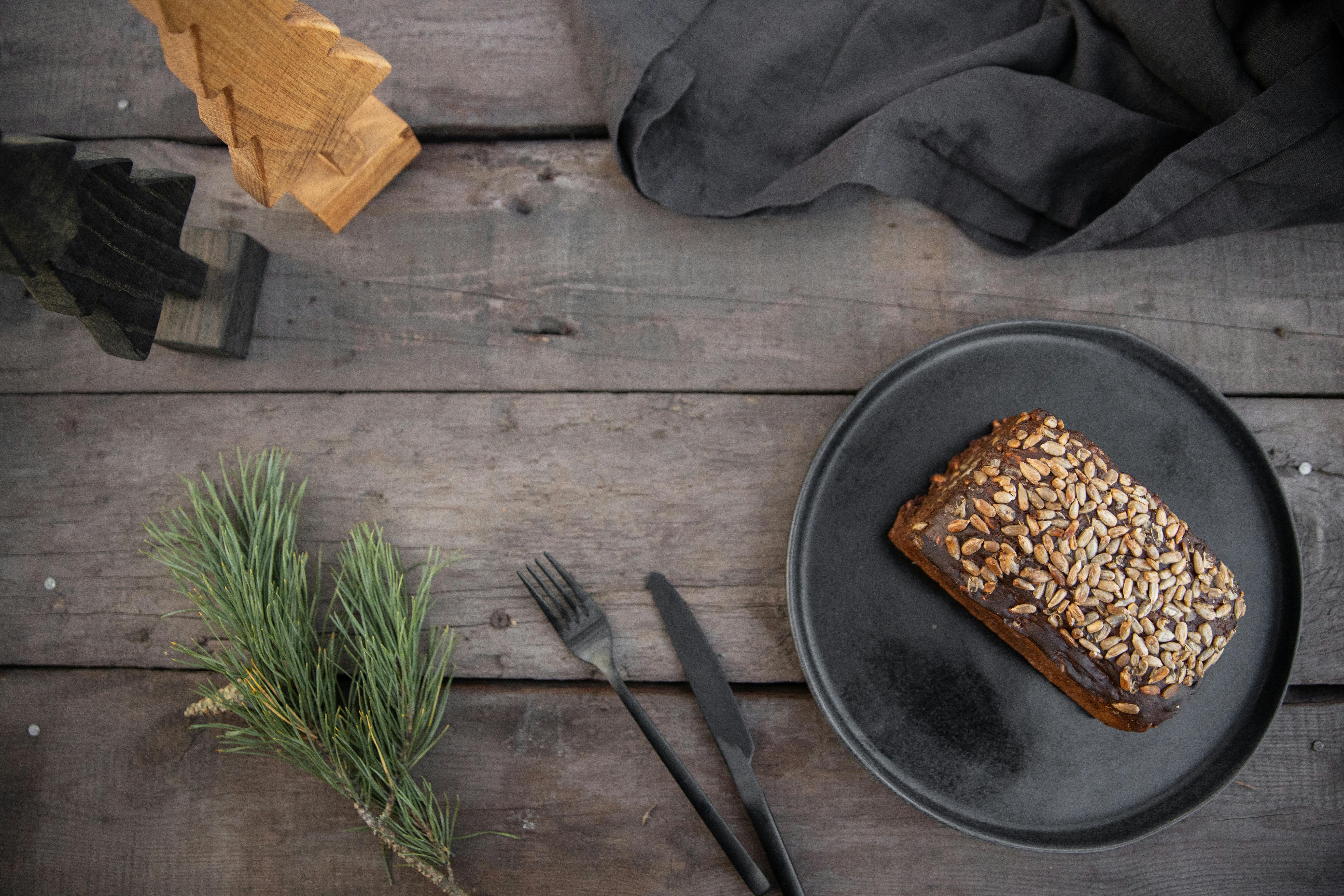 loaf bread with cereal toppings on black plate