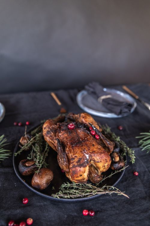 Free Delicious roasted turkey garnished with fresh herbs and cranberries, perfect for holiday feasts. Stock Photo
