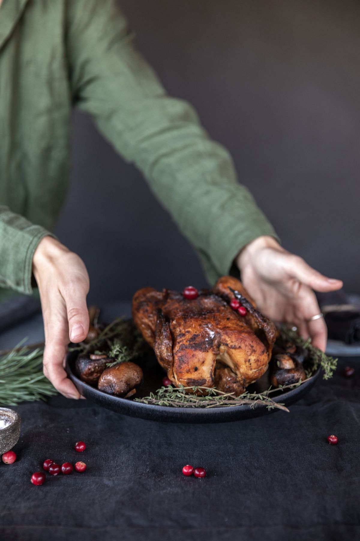 Chef presenting a roasted turkey garnished with herbs and berries
