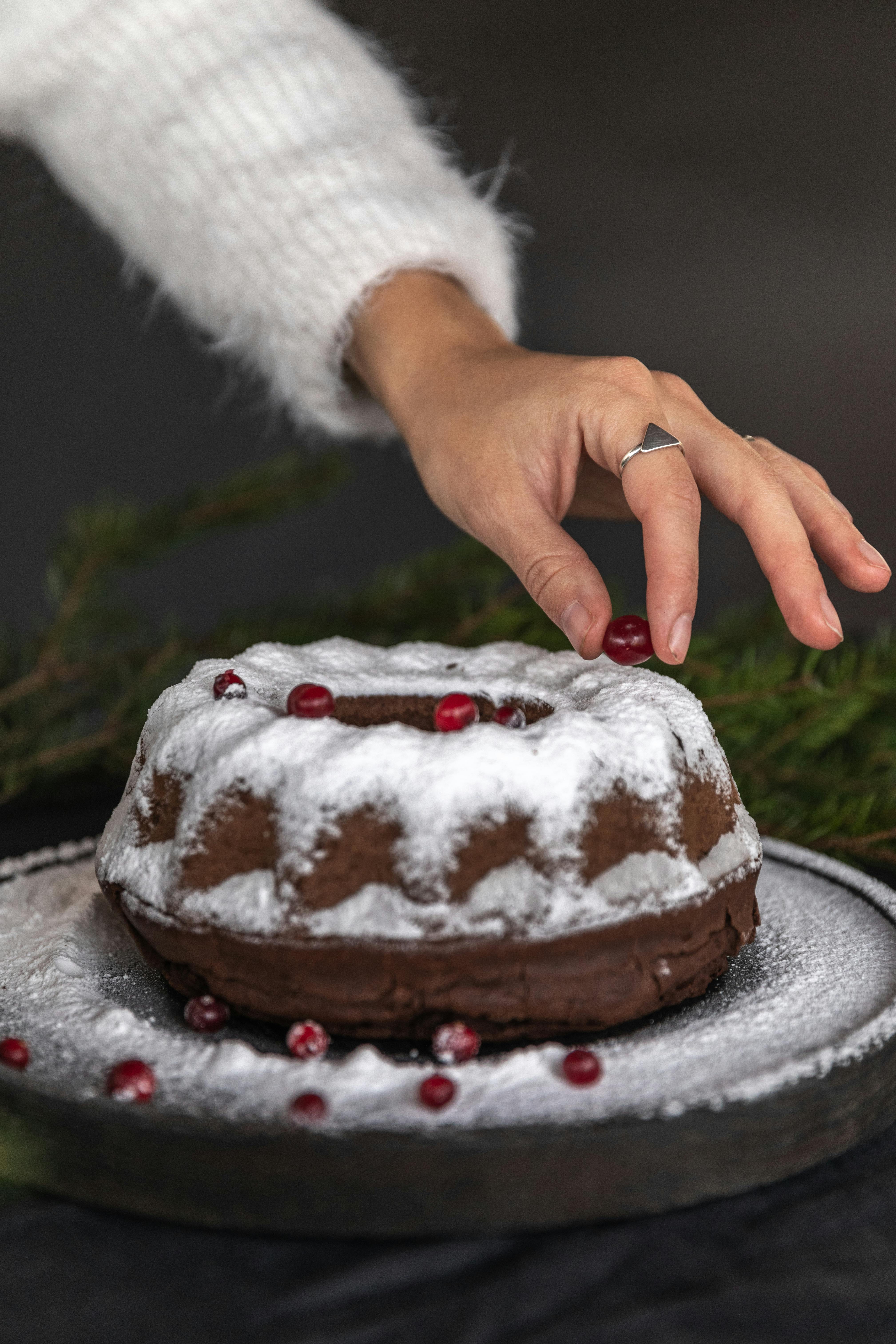 person holding white and brown cake