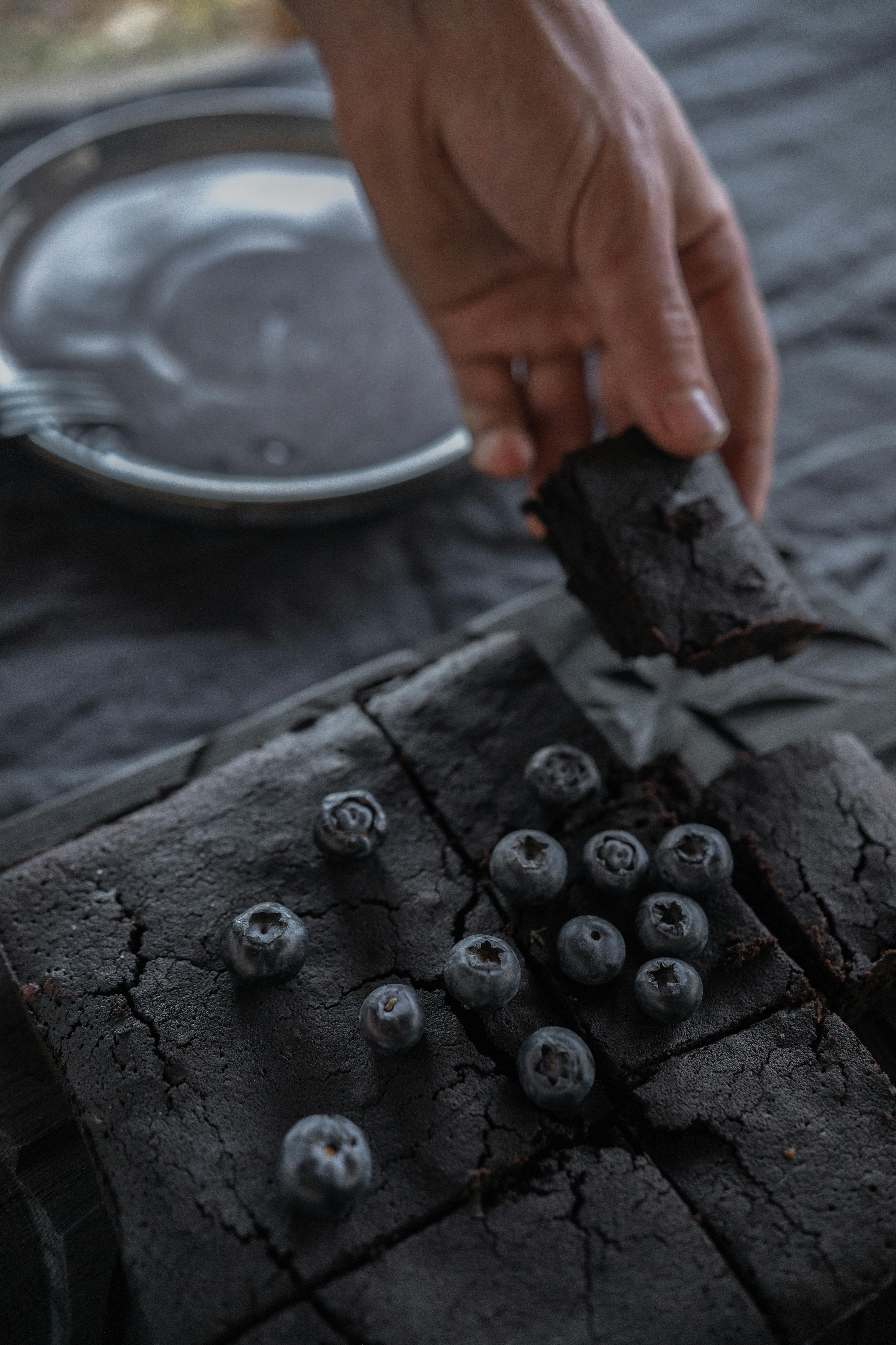 hand taking cake with blueberries