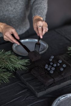 美味的黑巧克力蛋糕上铺着新鲜蓝莓，营造出舒适的冬季氛围