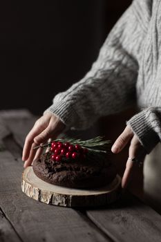 A cozy winter scene with a rustic chocolate cake topped with cranberries, perfect for holiday baking inspiration.