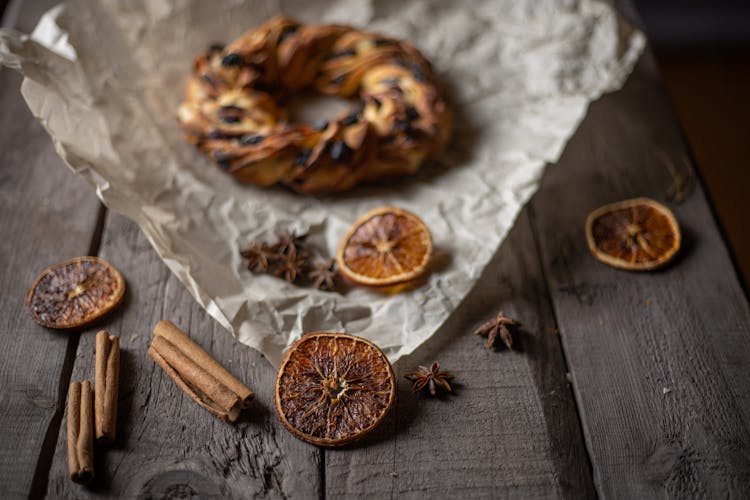 Bread On Baking Paper Beside Dried Orange Slices