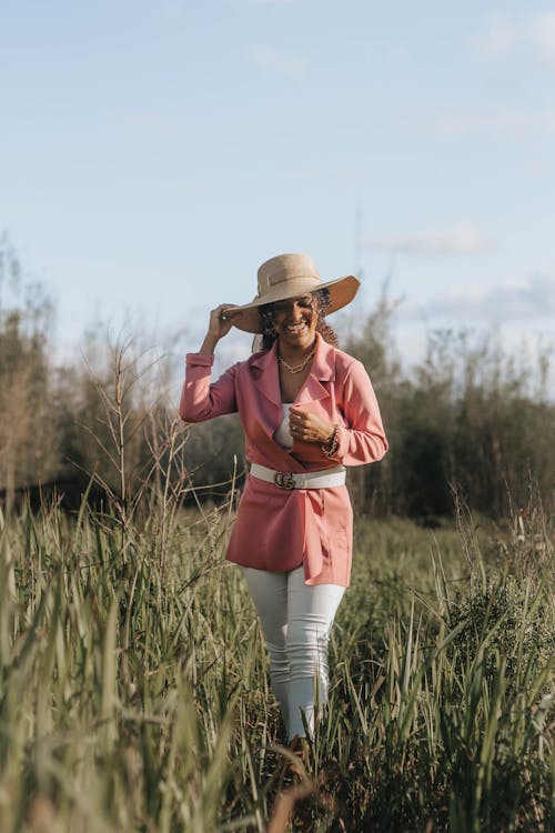 Woman Wearing a Blazer Standing on Grass Field