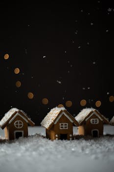 Beautifully decorated gingerbread houses with frosting snowflakes and warm bokeh lights creating a festive winter scene.