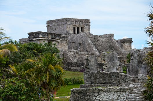 Explore the ancient Mayan ruins of Tulum near Cancún, surrounded by lush greenery and historic structures.