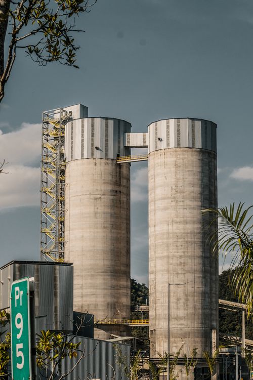 Free Vertical shot of silos at a cement plant in Colombia with industrial landscape. Stock Photo