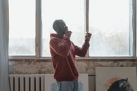 一名男子在室内戴着耳机，侧身跳舞欣赏音乐