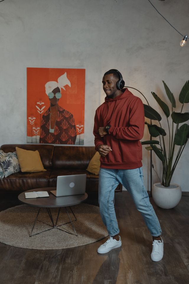 Hombre con auriculares bailando en el salón de su casa