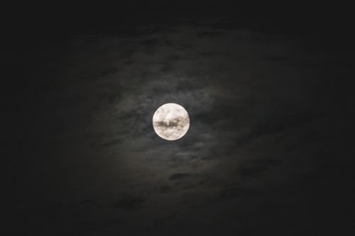 Free Captivating full moon surrounded by clouds, creating a moody night atmosphere. Stock Photo
