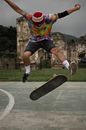 Man in Black Shorts and White Sneakers Doing Stunts on Gray Skateboard