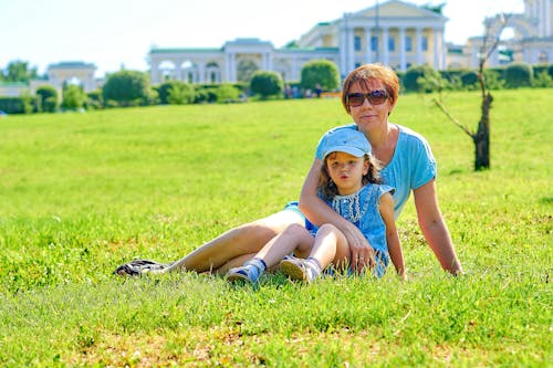 Free Mother and Daugther Sitting on the Grass Field Stock Photo