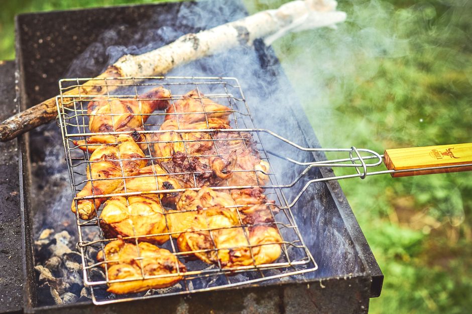 Bone-in, skin-on chicken thighs with charred grill marks resting on a wire rack next to a meat thermometer reading 175°F